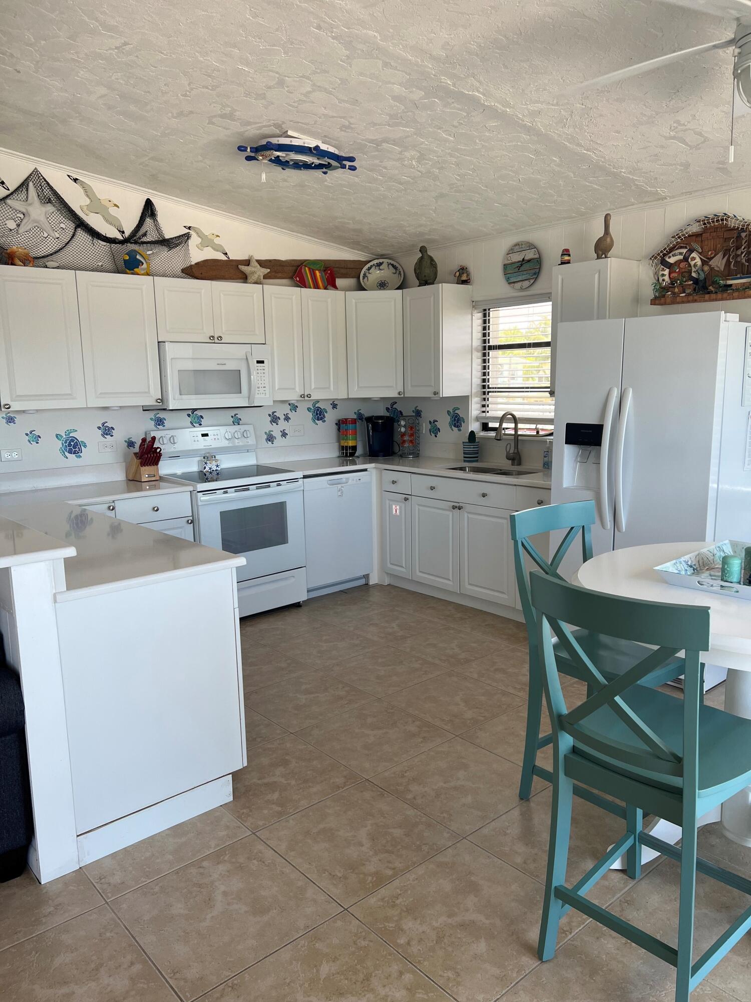 16 Shoreland Drive Key Largo, FL 33037 - Photo 4 of 16 a kitchen with a stove a table and chairs in it
