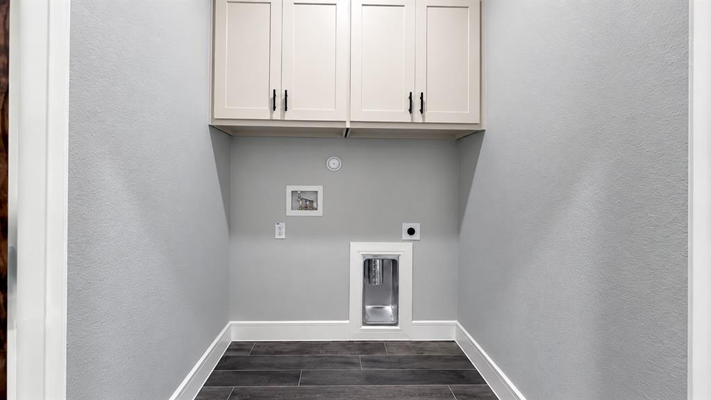 302-304 West Pine Street Whitewright, TX 75491 - Photo 34 of 38 Overhead cabinetry with matte black hardware, utility hookups, and wood-look flooring
