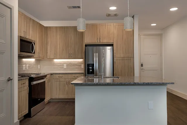 a kitchen with stainless steel appliances granite countertop a refrigerator and a stove top oven