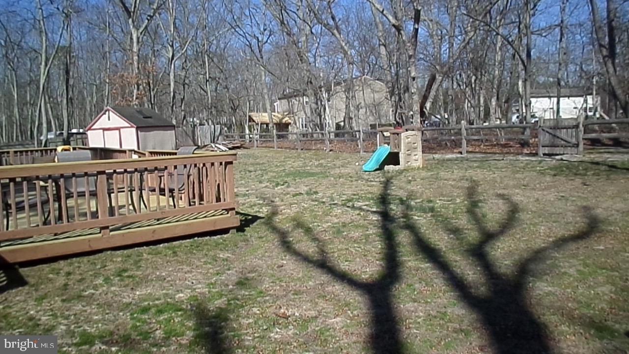 129 Country Lane Sicklerville, NJ 08081 - Photo 45 of 53 a view of a wooden deck with chairs and a yard