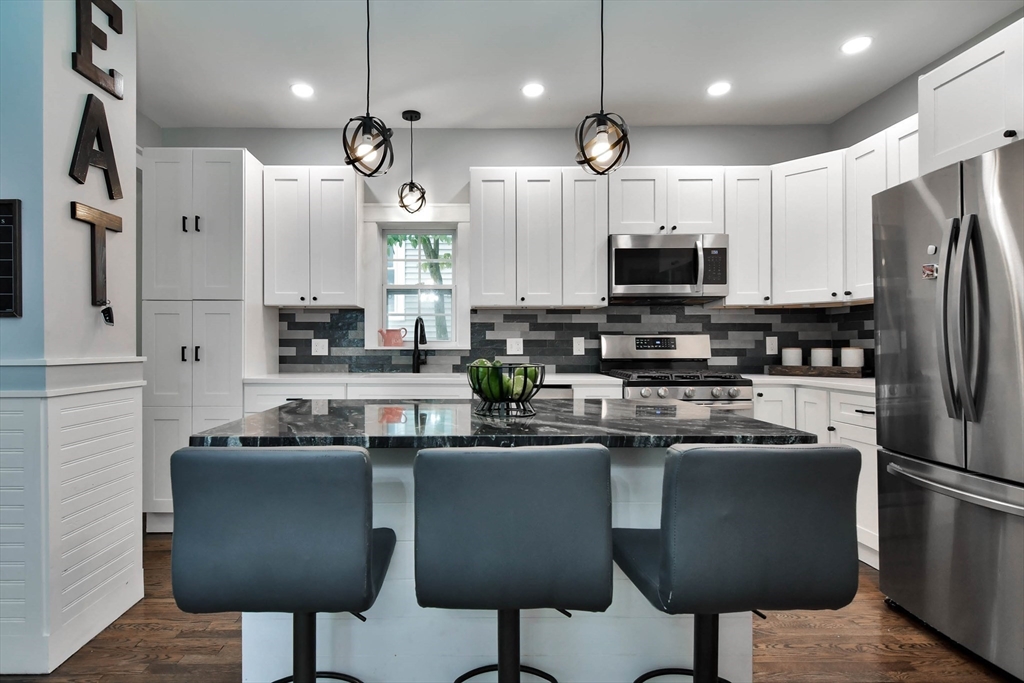 15 Balcomb Street Salem, MA 01970 - Photo 7 of 42 a kitchen with stainless steel appliances granite countertop a refrigerator a stove a sink and a microwave