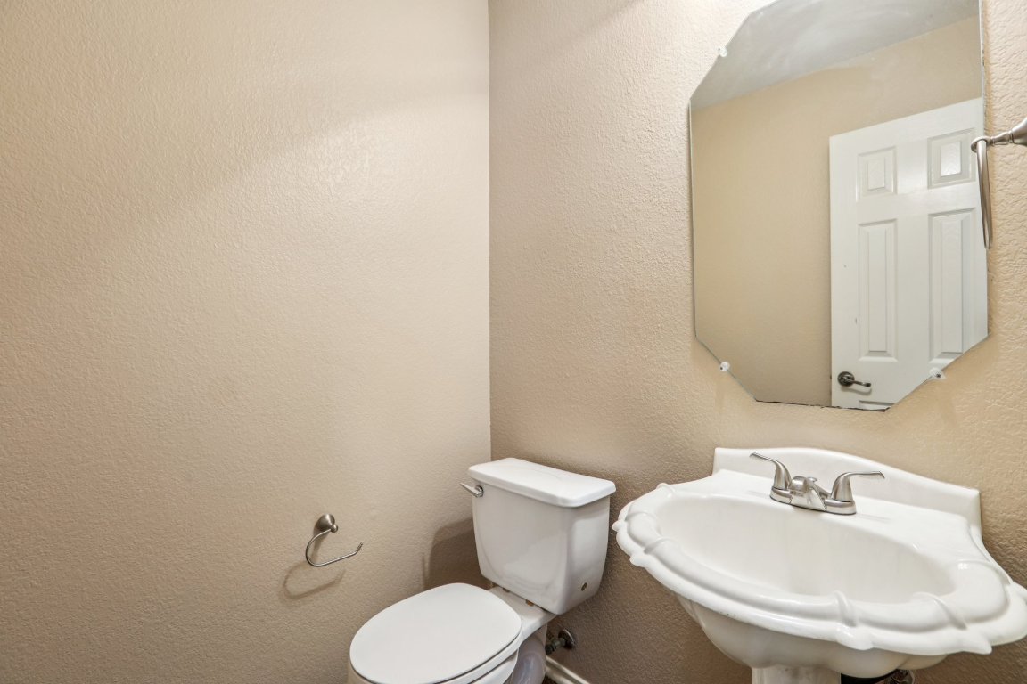 1132 Pine Portage Loop Leander, TX 78641 - Photo 13 of 39 a white toilet sitting next to a bathroom sink