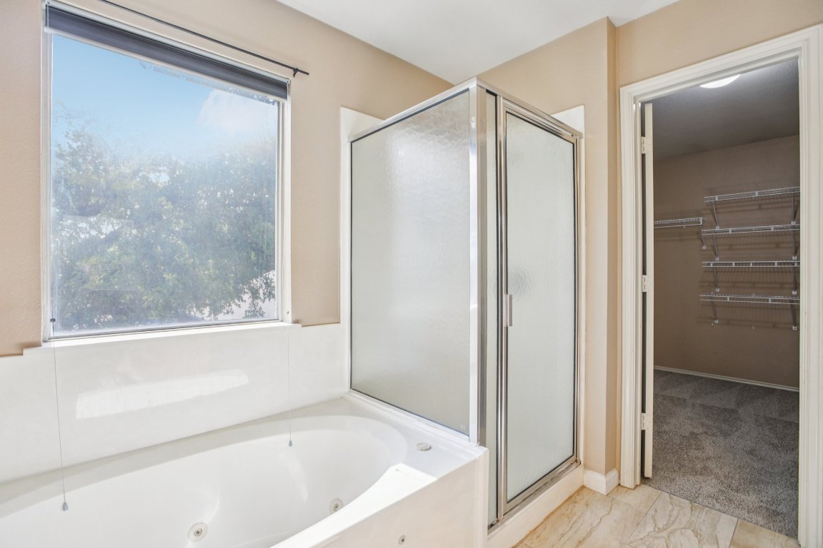 1132 Pine Portage Loop Leander, TX 78641 - Photo 21 of 39 a bathroom with a bathtub and a shower