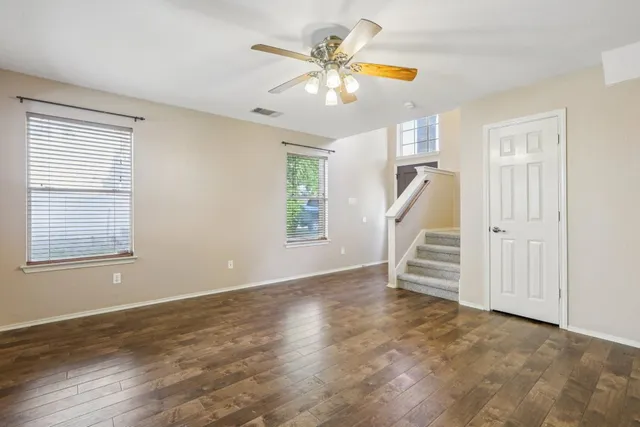 wooden floor in an empty room with a ceiling fan