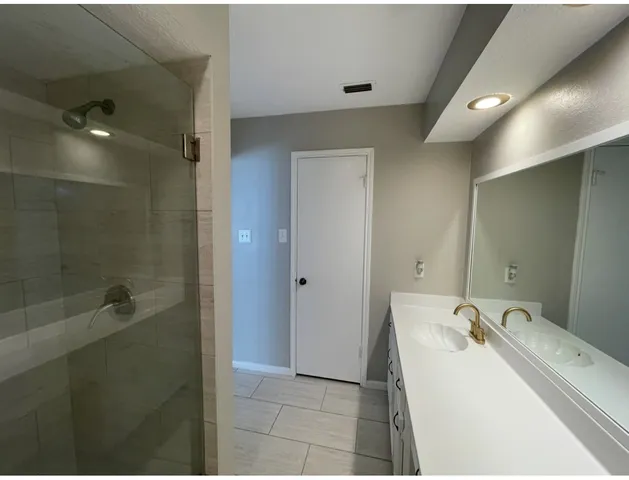 a bathroom with a sink a shower and mirror