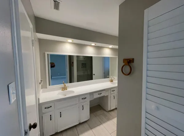 a bathroom with a double vanity sink and a mirror