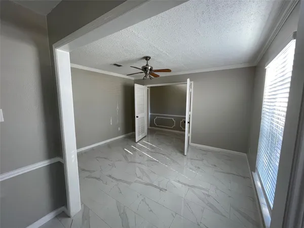 an empty room with windows and cabinet