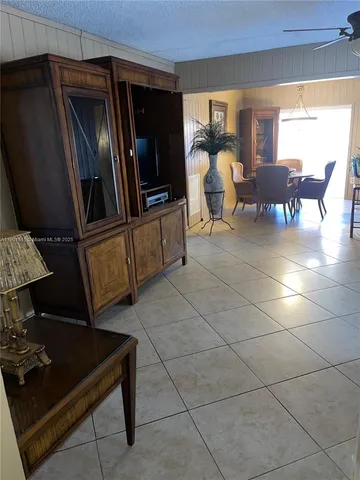 a living room with patio furniture and a flat screen tv