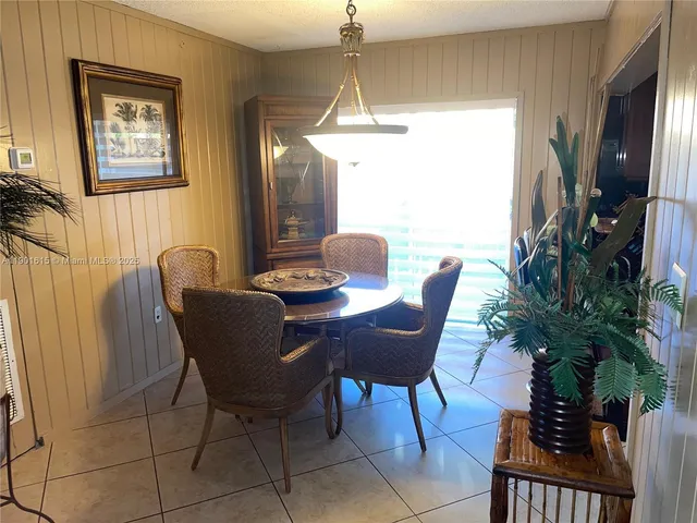 a dining room with furniture potted plants and wooden floor