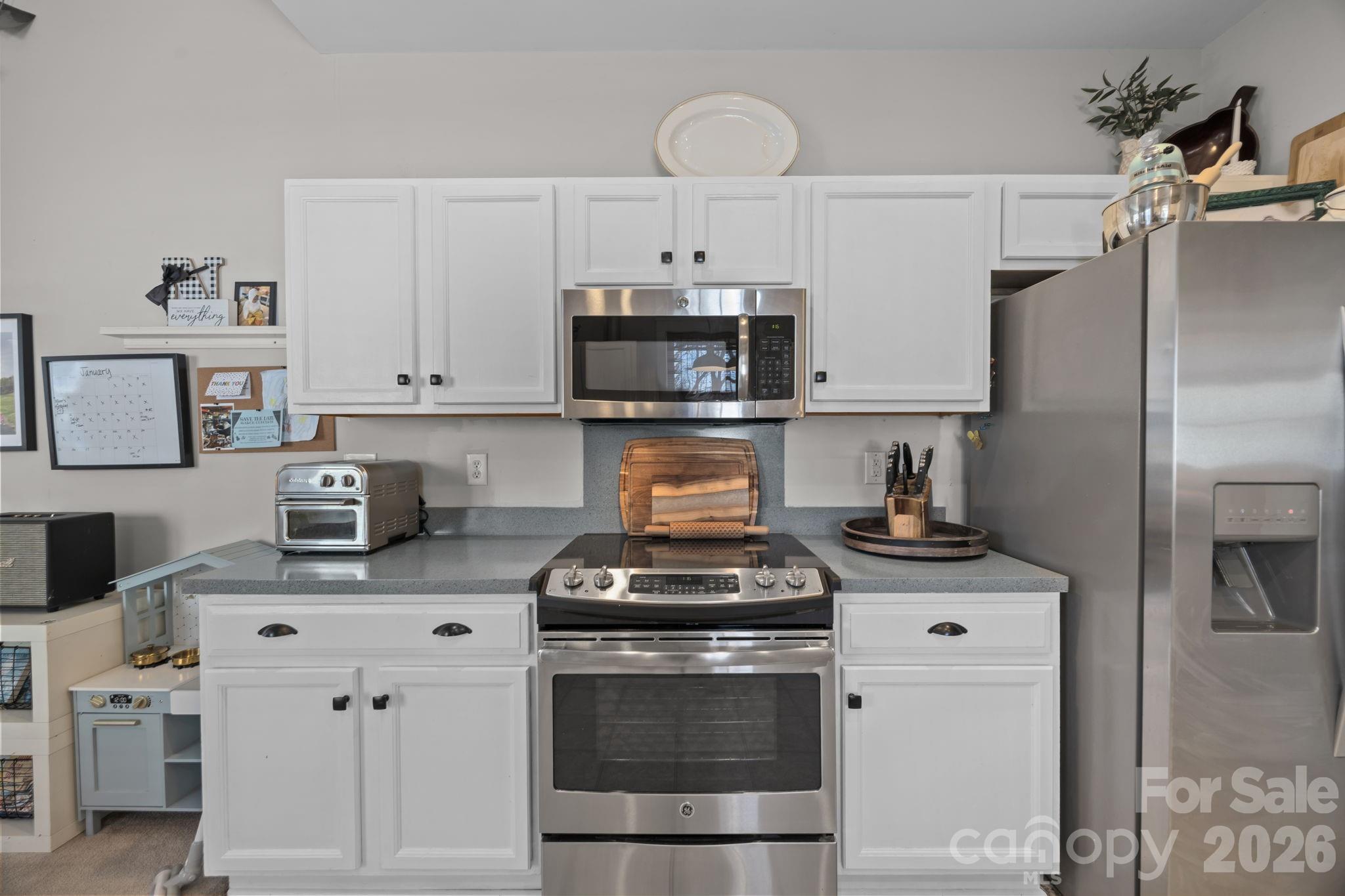 8111 Bud Henderson Road Huntersville, NC 28078 - Photo 13 of 39 a kitchen with stainless steel appliances granite countertop a stove a refrigerator and a white cabinets