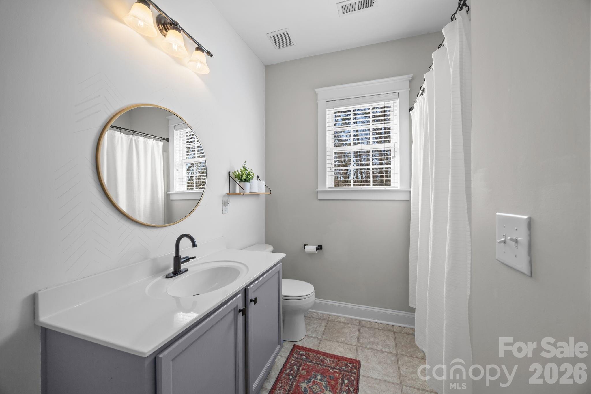 8111 Bud Henderson Road Huntersville, NC 28078 - Photo 21 of 39 a bathroom with a sink a toilet and a mirror