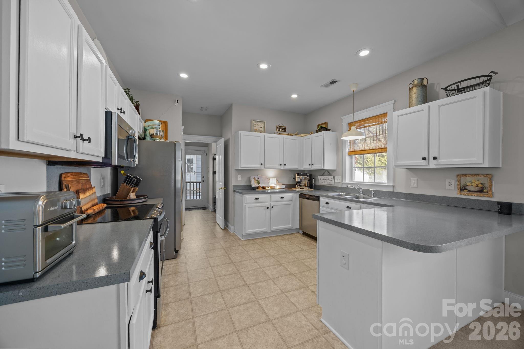 8111 Bud Henderson Road Huntersville, NC 28078 - Photo 10 of 39 a kitchen with stainless steel appliances granite countertop a sink and cabinets