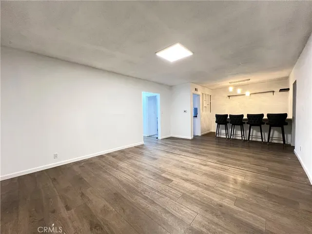 an empty room with wooden floor and furniture