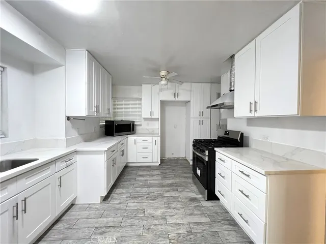 a kitchen with white cabinets and white appliances