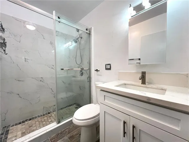 a bathroom with a sink a toilet and shower