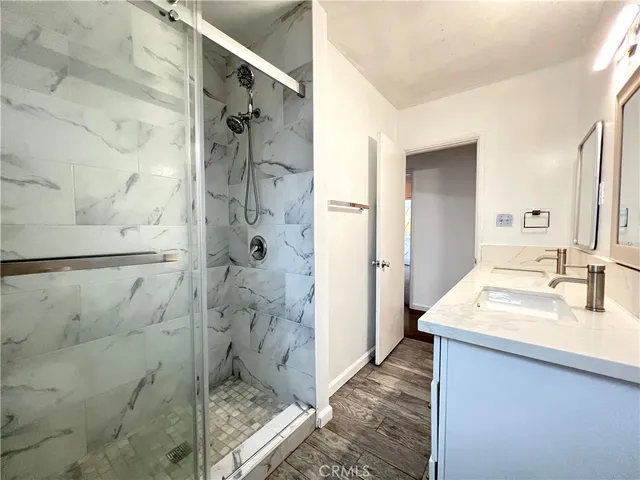 a bathroom with a shower sink and mirror