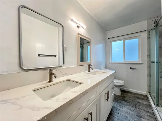 a bathroom with a double vanity sink mirror and toilet