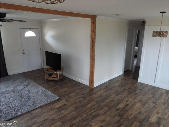a view of a livingroom with wooden floor and a flat screen tv