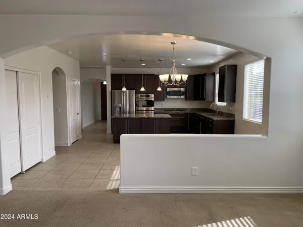 a view of living room kitchen with stainless steel appliances granite countertop cabinets and outdoor view