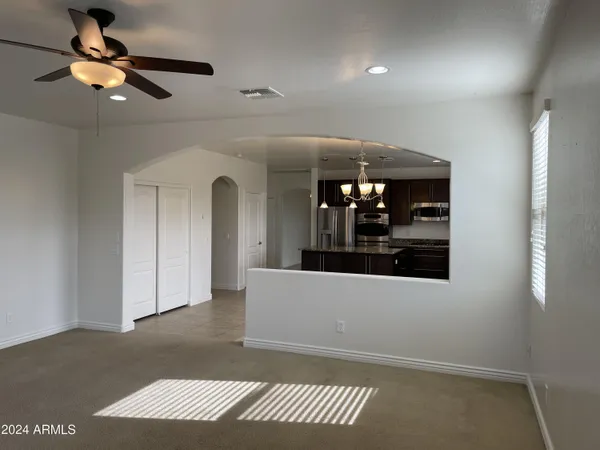 an empty room with closet and a chandelier fan