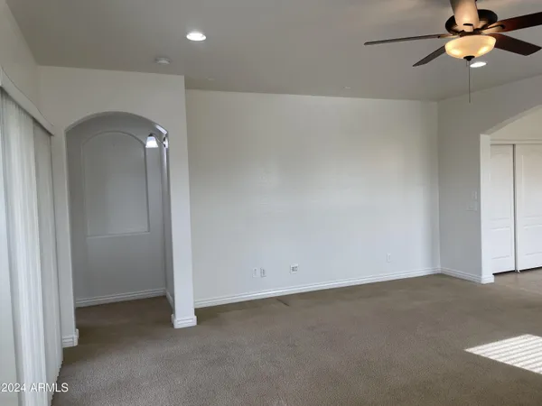 an empty room with a window and a fan
