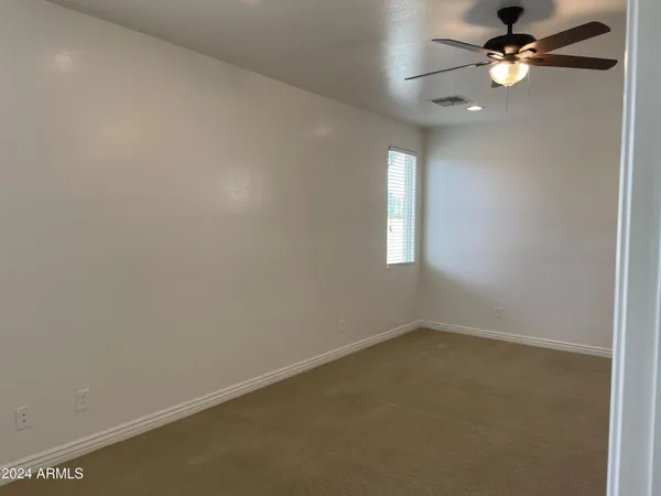 an empty room with a window and a fan