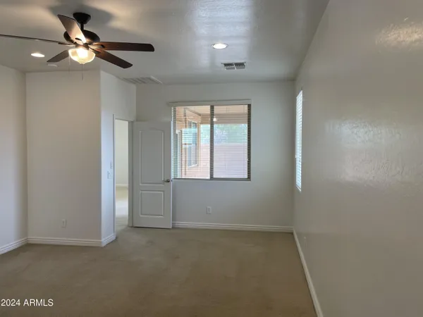 an empty room with closet and a chandelier fan