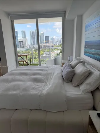 a bed sitting in a bedroom next to a large window
