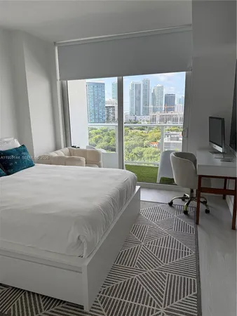 a bedroom with a bed a table and a window