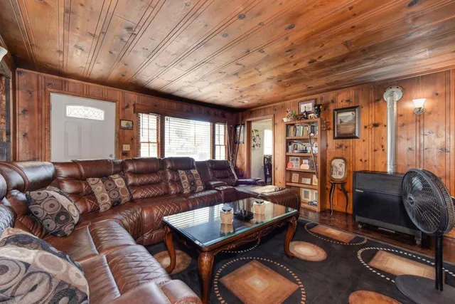 a kitchen with stainless steel appliances granite countertop a refrigerator a sink dishwasher a dining table and chairs with wooden floor