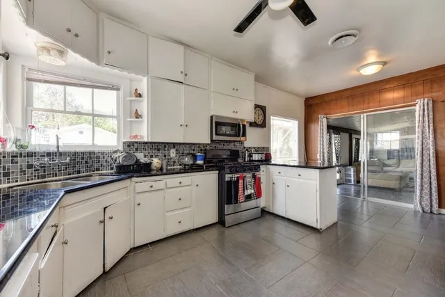 a view of house with backyard and trees in the background