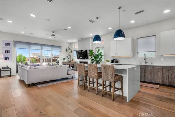 a living room with furniture kitchen and a wooden floor