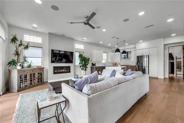 a living room with furniture kitchen view and a refrigerator