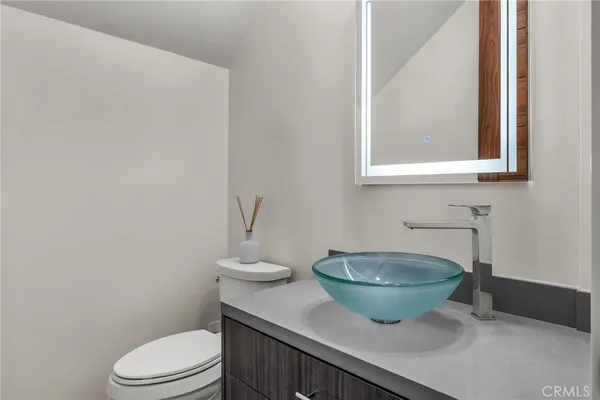 a bathroom with a granite countertop toilet and a sink