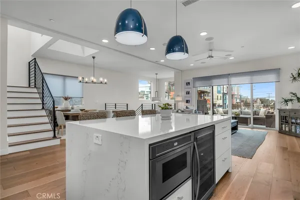 a kitchen with stainless steel appliances granite countertop a sink a stove and a wooden floors