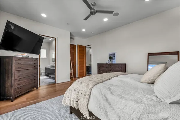 a spacious bedroom with a bed and a flat screen tv