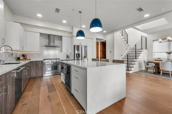 a large kitchen with stainless steel appliances kitchen island granite countertop a large counter top and a sink