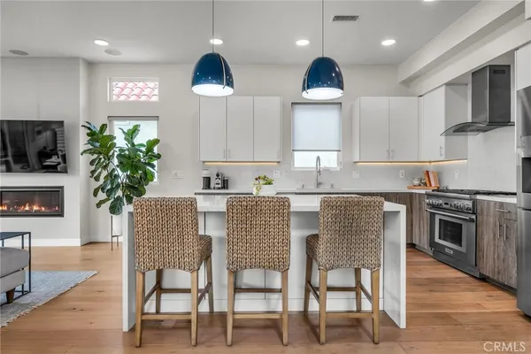 a kitchen with stainless steel appliances granite countertop a kitchen island hardwood floor sink and stove