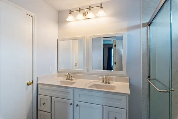a bathroom with a shower sink and mirror