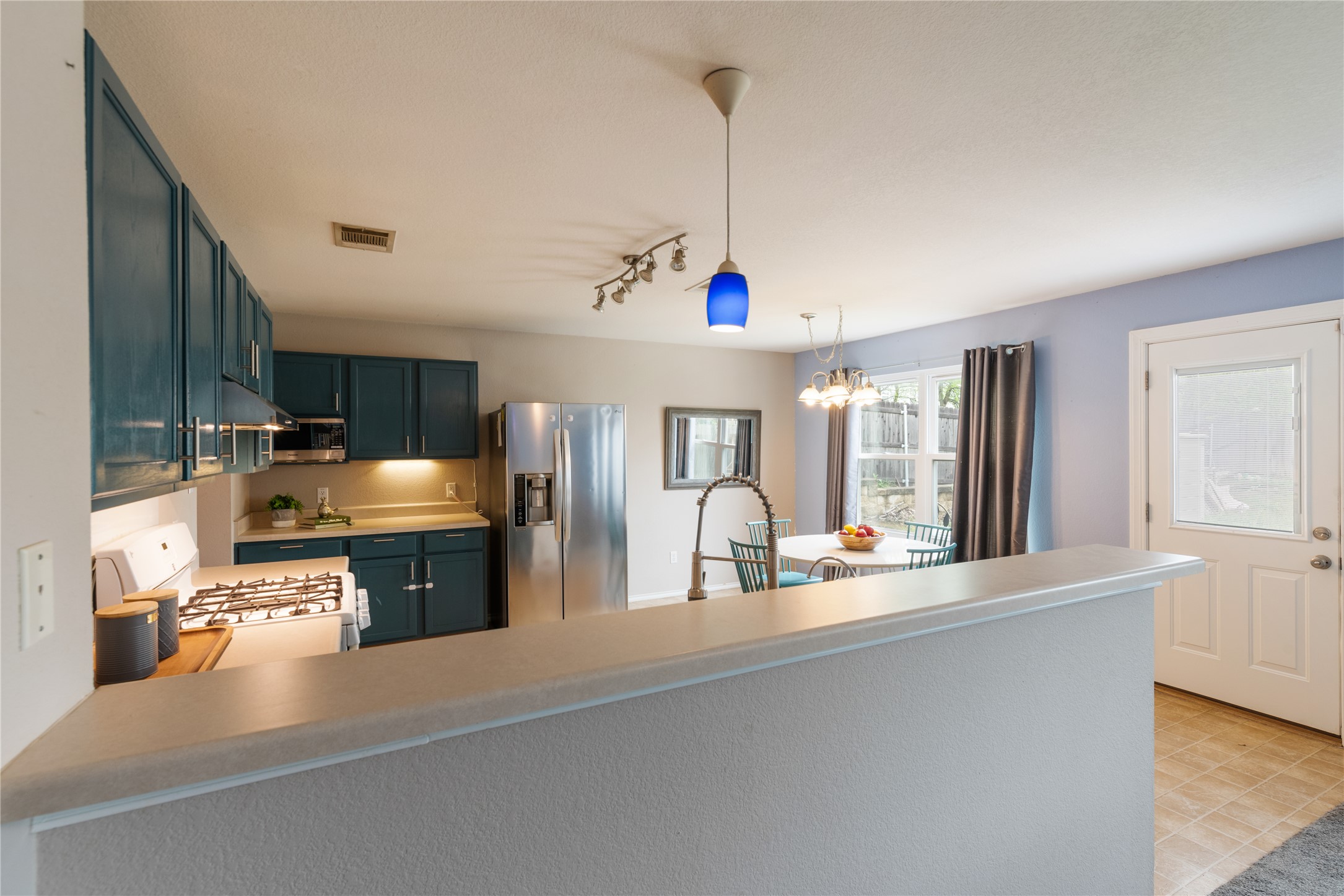 1329 Amberwood Loop Kyle, TX 78640 - Photo 27 of 27 a open kitchen with stainless steel appliances granite countertop a sink dishwasher stove and refrigerator with wooden floor