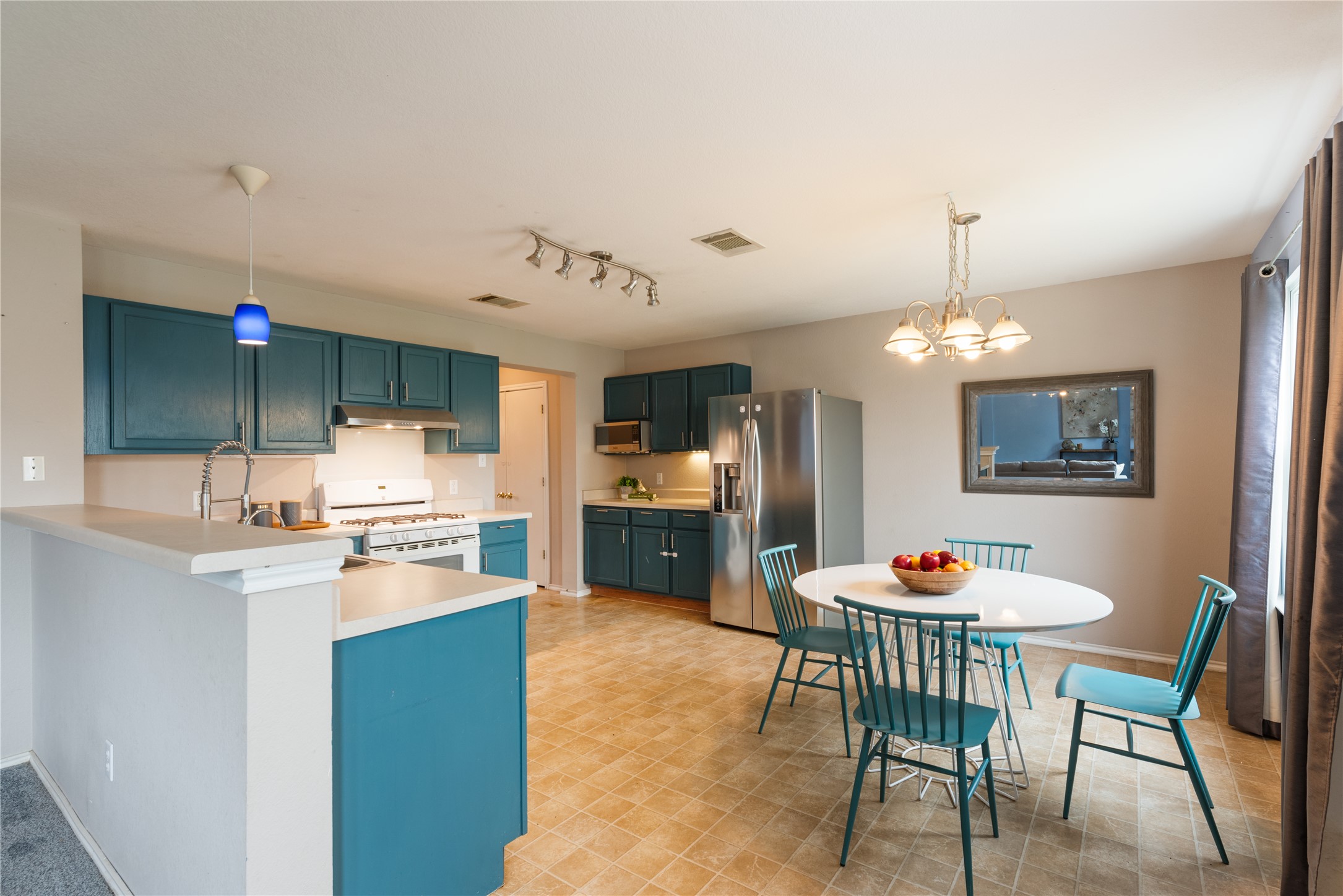 1329 Amberwood Loop Kyle, TX 78640 - Photo 4 of 27 a open kitchen with stainless steel appliances kitchen island a table and chairs in it