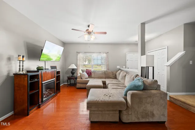 a living room with furniture a flat screen tv and a chandelier