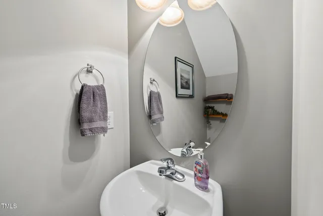 a bathroom with a sink and mirror with toilet