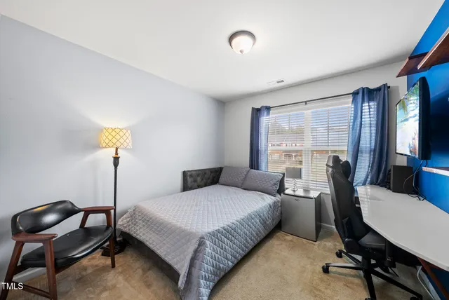 a bedroom with a bed a table and chair