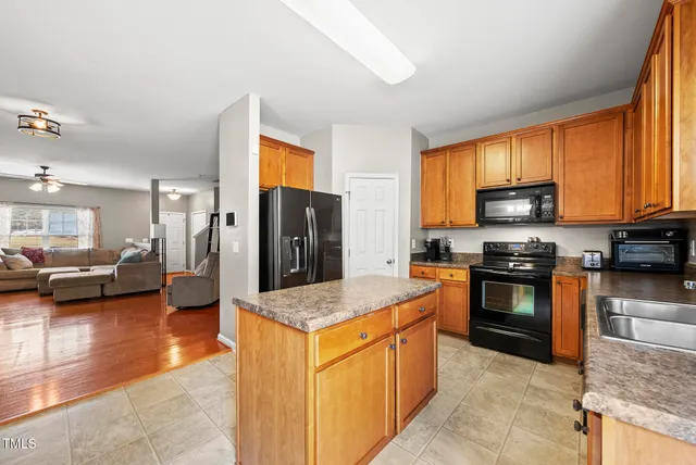 a kitchen with stainless steel appliances granite countertop a stove refrigerator and a sink