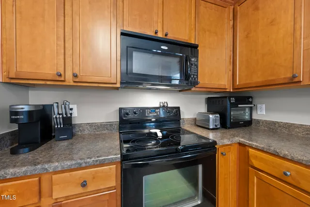a kitchen with stainless steel appliances granite countertop a stove a microwave and cabinets
