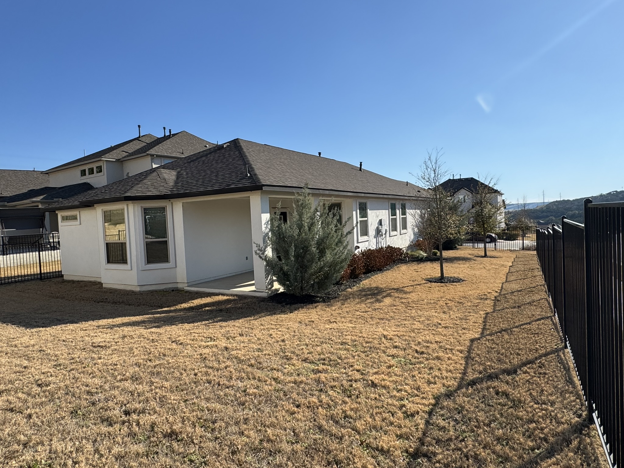 4500 Modena Bend Leander, TX 78641 - Photo 12 of 22 Back of house with a fenced backyard, stucco siding, and roof with shingles