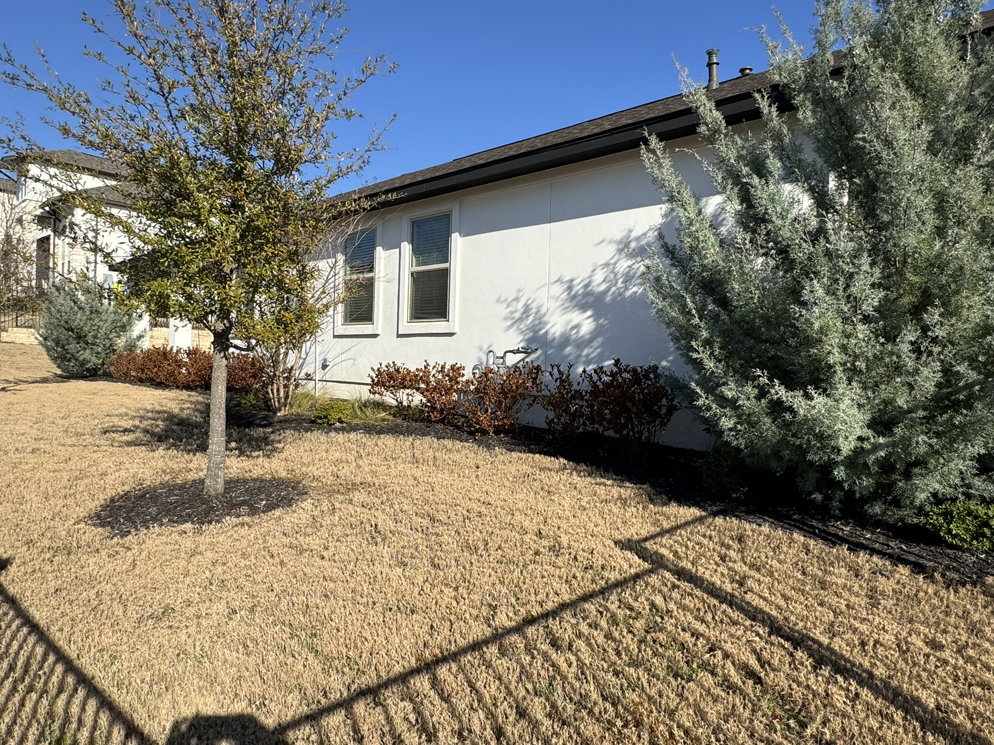 4500 Modena Bend Leander, TX 78641 - Photo 14 of 22 View of side of property with stucco siding and a lawn