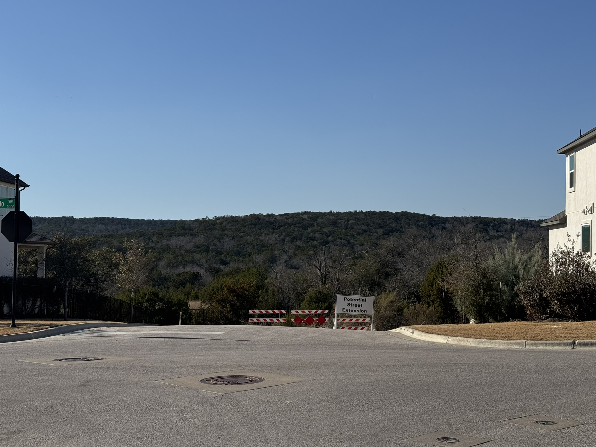 4500 Modena Bend Leander, TX 78641 - Photo 15 of 22 View of asphalt street with curbs, a forest view, and traffic signs