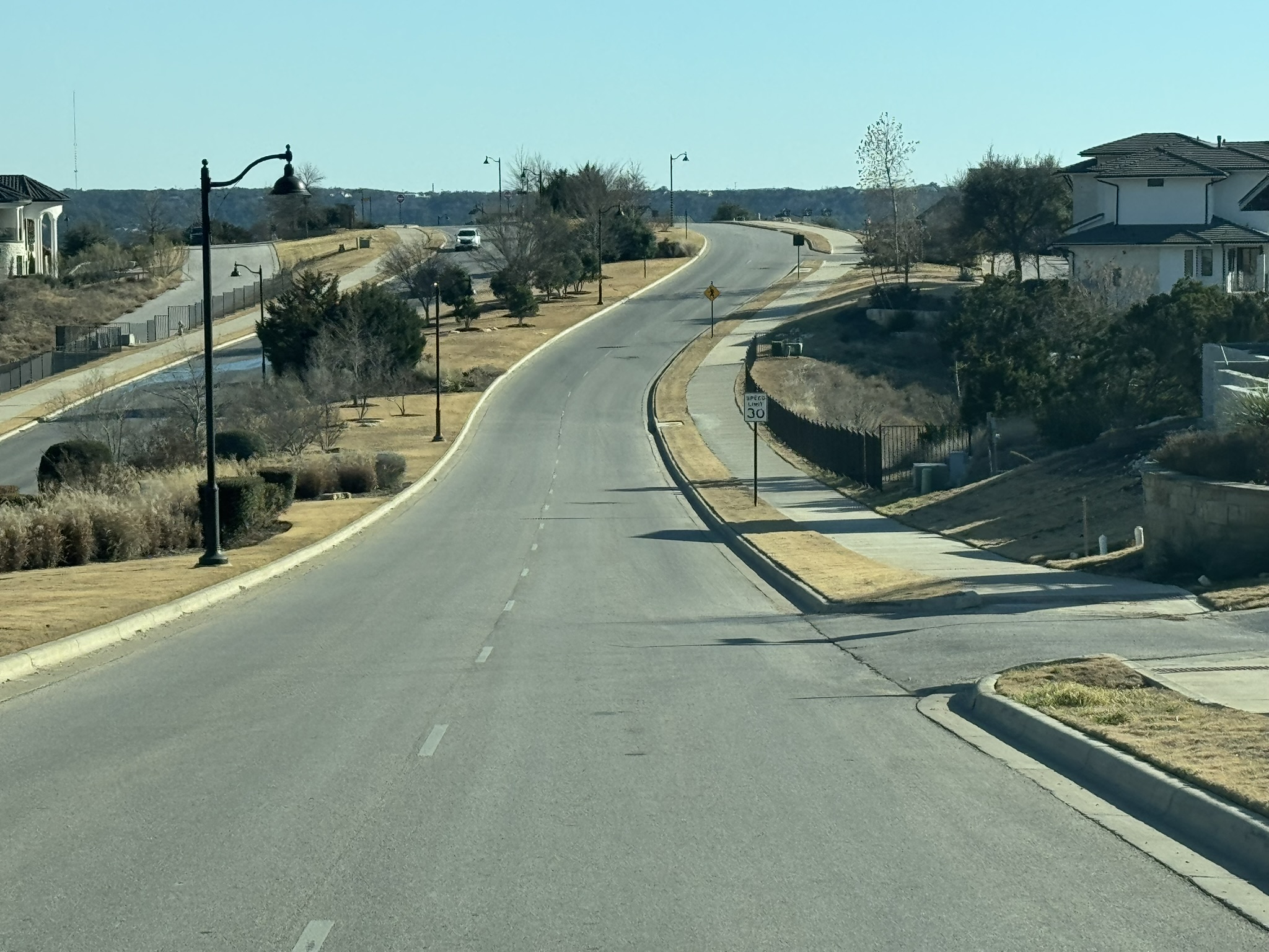 4500 Modena Bend Leander, TX 78641 - Photo 16 of 22 View of asphalt road with curbs, sidewalks, and street lights